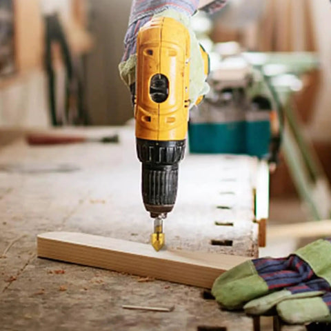 Yellow drill using the Six Piece Countersink Drill Bit Set With One Quarter Inch Hex Shank on a wooden board