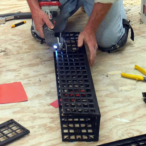 Person cutting Kirb Perfect KP-543 Shower Curb Guard, fiberglass filled ABS, adjustable, showing non rotting liner protection