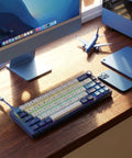 Absolute Beast 60 Percent Mechanical Gaming Keyboard With Gasket Mount And Rgb Backlighting Volume Knob Pbt Keycaps Mda Profile Qmk Via Hot Swappable Layout For Late Night Grinding And Vibing Blue Edition on a desk next to a monitor.