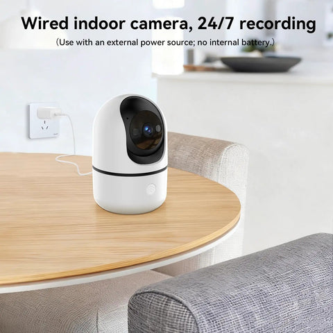 Indoor Security Camera Set With 5G And 2.4G WiFi, 360-Degree Pan Tilt, shown on wooden table, plugged in near wall outlet.
