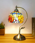 Rose Floral Stained Glass Table Lamp With Antique Brass Curved Base, Handmade Reading Lamp, LED Bulb Included on wooden table