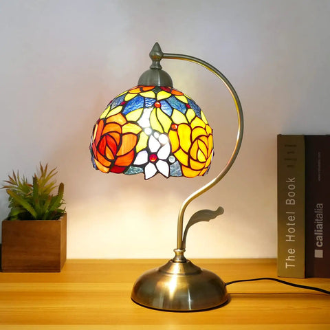 Rose Floral Stained Glass Table Lamp With Antique Brass Curved Base, Handmade Reading Lamp, LED Bulb Included on wooden table