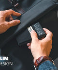 Man placing a slim minimalist RFID blocking wallet with ID window and pop-up card holder into a bag, showcasing everyday carry essentials.