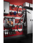 Advanced Bike Storage System V3 Claw for garages holds up to 50 lbs and tires up to 2.4 inches wide mounted on red garage wall