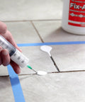 Person using syringe to apply Two Pack Loose Tile Repair Adhesive With Syringe For Tile Porcelain Ceramic Marble Stone And Wood Floors Extra Strength Bonding That Rebounds Loose Or Hollow Tiles Without Demolition on tiled floor