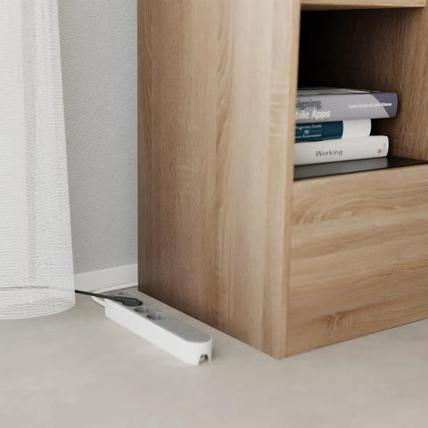Slick Black Smart Power Strip With WiFi App Control, Heavy Duty Surge Protector, Built In USB Charging Ports, Total Game Changer For Your Home Office Or Gaming Rig Setup beside a wooden shelf.