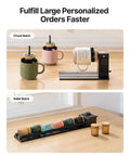 xTool RA3 smart rotary engraver on base; three mugs in green, pink and beige nearby; roller batch rack with cups.