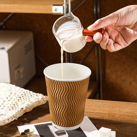Pouring milk into No Sleeve Needed 12 Oz Ripple Wall Corrugated Insulated Paper Cups With Anti Scald Grip For Hot Or Cold Drinks Great For Office Cafe Party Or Travel 120 Pack