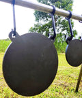 AR500 Steel Gong Target 3 Eighths Inch Thick For Precision Shooting hanging on a stand outdoors