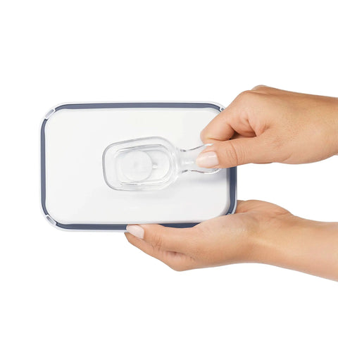 Hands holding a clear coffee scoop attached under a POP storage container lid, 2 tbsp 30 mL capacity, durable kitchen accessory.