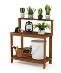 Tioman Outdoor Potting Bench In Natural Hardwood For Small Patios And Balconies With A Tall Open Frame And Slatted Shelves That Drain Water Big On Workspace And Handy Storage For Tools And Plants with plants and gardening tools displayed.