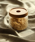Premium Glass Coffee Canister With Secure Locking Lid Wide Mouth Kitchen Storage Jar For Beans Sugar Loose Tea Clear Airtight Food Container filled with pasta on soft fabric.