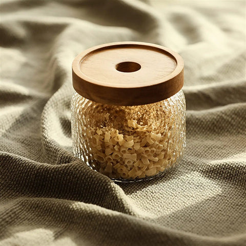 Premium Glass Coffee Canister With Secure Locking Lid Wide Mouth Kitchen Storage Jar For Beans Sugar Loose Tea Clear Airtight Food Container filled with pasta on soft fabric.