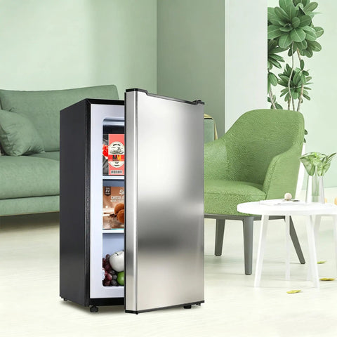 Effortless 3.6 Cu Ft Upright Freezer Glossy Silver in modern living room with green chair and white table.