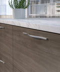 Brushed Nickel Modern Arched Cabinet And Drawer Pull Handle for kitchen and bath, installed on wooden cabinets.