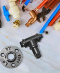 Plumbing fittings including iron flange, T-joint, and assorted pipes and tools on marble surface