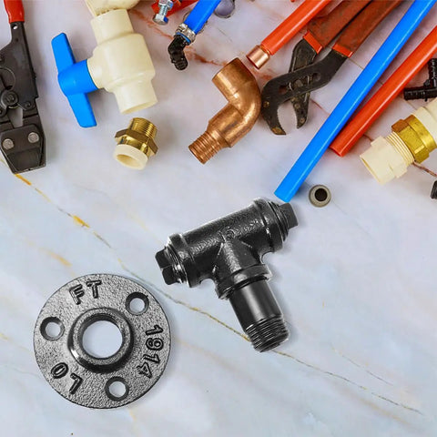 Plumbing fittings including iron flange, T-joint, and assorted pipes and tools on marble surface
