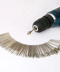 Side view of a stone carving diamond burr bit set, 50 pieces with 1/8 in shank, arranged beside a rotary drill