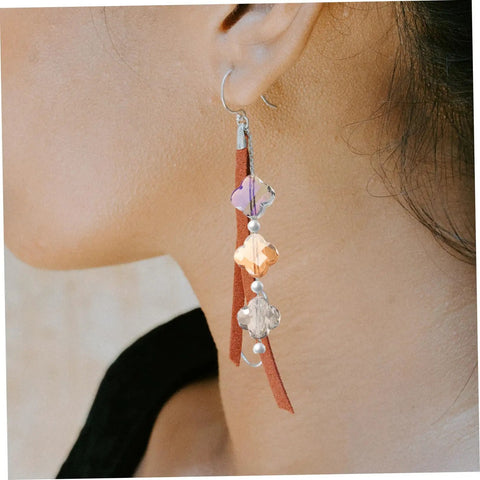 Earring featuring drilled glass spacer beads with purple and orange tones, combined with leather accents for DIY jewelry making.