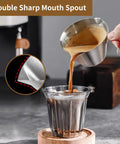 Pouring espresso from Two Pack Stainless Steel Espresso Cups With Handle And Double Spout Measuring Cup With Dual Scale 3.4 Oz 100 Ml V Shaped Mouth Durable Coffee Shot Glasses For Home Barista Vibe into glass