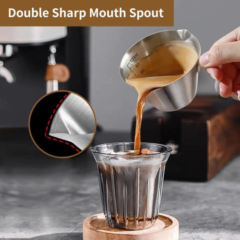Pouring espresso from Two Pack Stainless Steel Espresso Cups With Handle And Double Spout Measuring Cup With Dual Scale 3.4 Oz 100 Ml V Shaped Mouth Durable Coffee Shot Glasses For Home Barista Vibe into glass