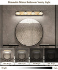 Sleek 4 Light Dimmable Bathroom Vanity Light Fixture Over Mirror, Modern LED Acrylic Wall Lights In Black And Gold, 26 Inch Long, 4000K Neutral White, 20W, 110V AC shown above a round mirror on a gray wall