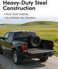Black truck with in-bed spare tire bracket, showcasing beefy heavy duty steel construction on open road