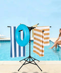 Outdoor Pool Towel Rack, Freestanding 42 to 71 Inch Adjustable Stand With Four Legs and Six Foldable Arms at poolside with towels and float