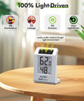 Light Driven Thermo Hygrometer displaying temperature and humidity levels on a wooden table, part of plant care sensor kit.