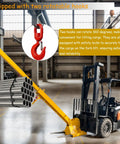 Heavy Hitter Telescoping Forklift Jib Boom Crane Attachment with dual hooks for safe cargo lift in warehouse setting.