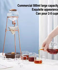 Polished Glass Cold Brew Coffee Maker Featuring Precise Drip Valve And Rugged Stainless Steel Base serving iced tea on a table with cups.