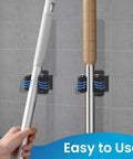 Heavy Duty Stainless Steel Broom And Mop Wall Mount Hanger, 4 Piece Set With Screws, mounted on a wall holding tools, black.