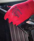Close-up of red Tsunami Grip Mach Finish Nitrile Coated Gloves With Double Dipped Micro Finish for abrasion resistance and oil grip.
