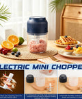 Portable Cordless Electric Garlic Chopper And Vegetable Dicer With 400ml Capacity For Onions Ginger Peppers on a table with fruits.