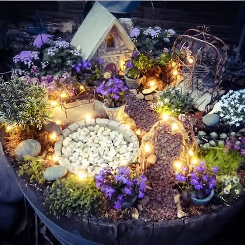 Miniature garden with warm white Solar String Lights 16 Feet 50 LEDs, illuminating pathway and plants at dusk.