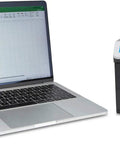 Laptop displaying spreadsheet next to New 2024 Mixed Denomination Money Counter And Counterfeit Detector For Eight Currencies