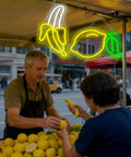 Bright Dope Banana Shaped LED Neon Sign Light for Bedroom Decor hanging at fruit market, warm yellow glow