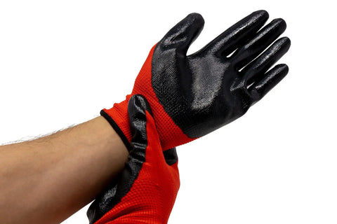 Person wearing red and black protective gloves adjusting them on wrist