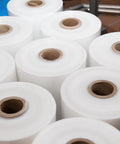 Rock Solid Heavy Duty Stretch Film Rolls For Machines, Clear 80 Gauge secure packing rolls stacked for industrial wrapping.