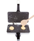 Authentic Italian Pizzelle Maker Electric Baker Press Makes Two 5 Inch Cookies with batter being poured onto non-stick plates.