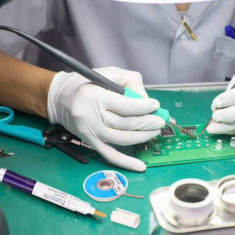 Hands using Soldering Pen And Solder Wick Kit For Electronics Repair With No Clean Pens and Braided Wick on circuit board