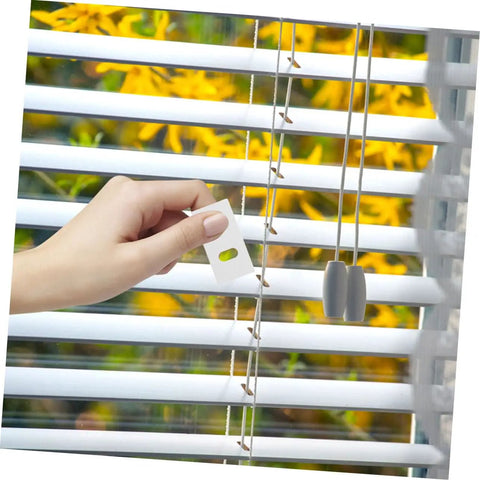 Hand using 50 Pack Vertical Blind Repair Tabs Kit Quick And Easy Fix For Vertical Blinds With Strong Adhesive Tabs Durable Replacement Parts For Damaged Slats And Broken Blinds