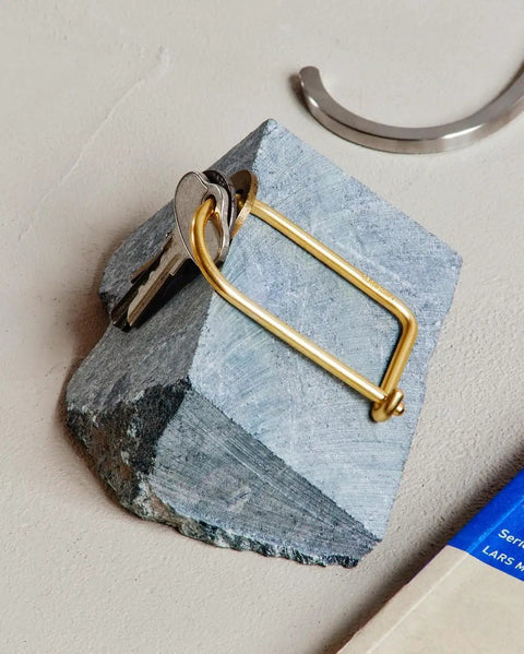 Wilson Brass Keyring With 2 Inch Carabiner Clip resting on stone surface, showcasing minimalist design and durable construction.
