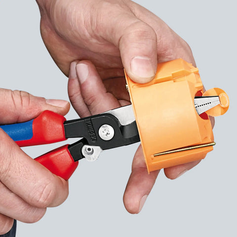 Using Electrical Installation Pliers 6 In 1 Multi Function Tool With Red Plastic Coated Handles And Black Atramentized Finish on an orange object