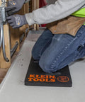 Tradesman kneeling on 1-inch thick NBR foam knee pad with handle, providing ultimate knee protection and comfort on job site