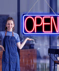 Person standing beside 16.5 X 9 Inch Led Neon Open Sign For Business Ultra Bright Plug In Light Up Open Sign With Blue Red Backplate.