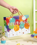 Person holding Colorful Balloons Birthday Gift Bag Set With Happy Birthday Text, Kid Friendly Gift Bag for Kids, 13 x 5 x 10 Inches, One Count