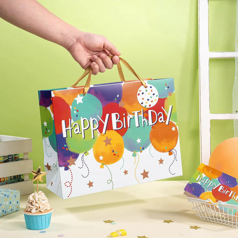Person holding Colorful Balloons Birthday Gift Bag Set With Happy Birthday Text, Kid Friendly Gift Bag for Kids, 13 x 5 x 10 Inches, One Count