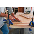 Six Inch Mini Bar Clamp Two Pack With One Hand Quick Release Trigger Rock Solid Grip Non Marring Pads in use on wood.
