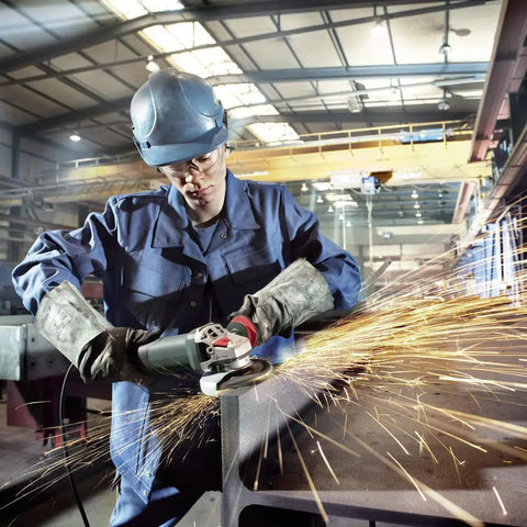 Worker using High Torque Angle Grinder With Electronic Variable Speed, 13.5 Amp, sparks flying during metal grinding in workshop
